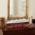 13" Black and Red RMS Queen Mary II Large Boat Hand Painted Decorative Boat styled in a furnished interior with a cream wall on a black floor.