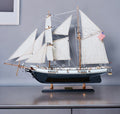 26" Black and White Solid Wood Hand Painted p-Oxybis(benzenesulfonyl hydrazide) Model Boat shown outdoors on a tiled patio.