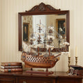 18" Wood Brown Solid Wood Hand Painted San Felipe 1690 Small Model Boat styled in a furnished interior with a cream wall on a dark wood floor.