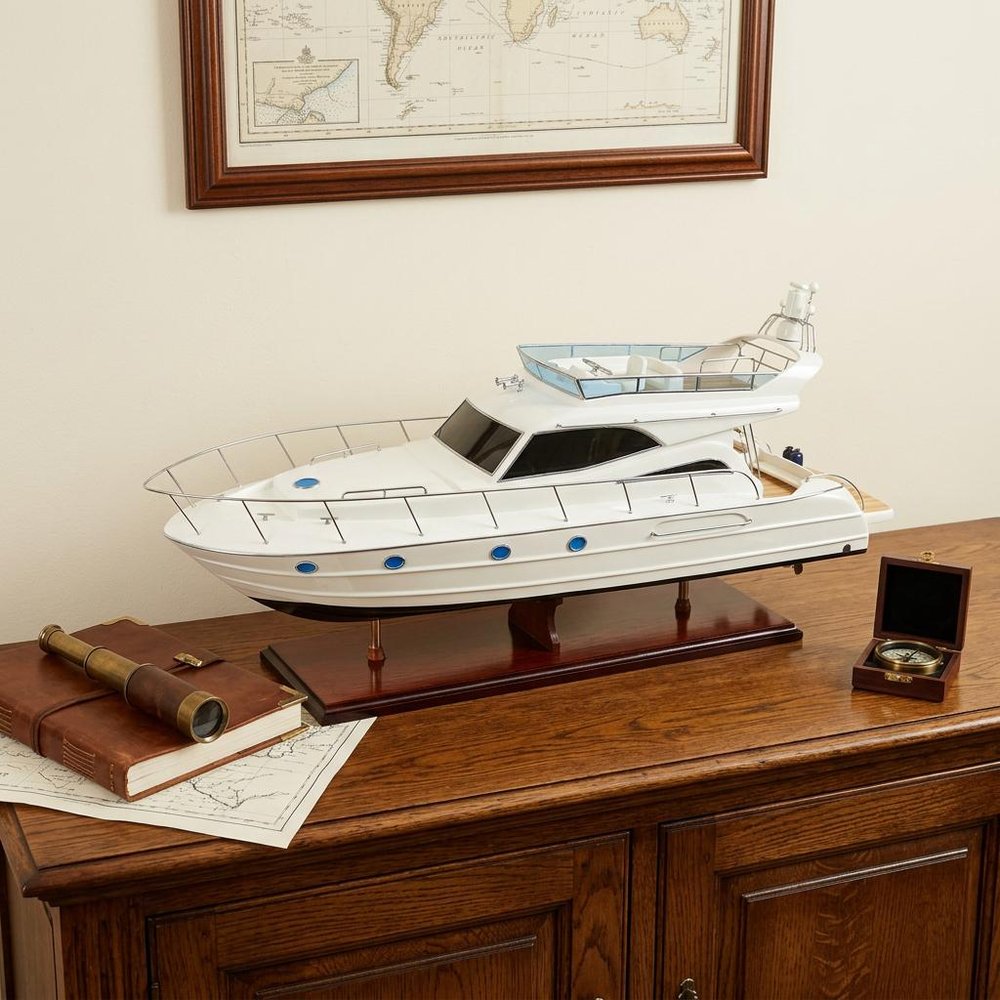 19" White Solid Wood Hand Painted Model Boat styled in a furnished interior with a cream wall on a dark wood floor.