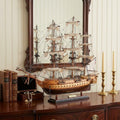 20" Wood Brown Solid Wood Hand Painted 1797 USS Constitution Small Model Boat styled in a furnished interior with a cream wall on a black floor.