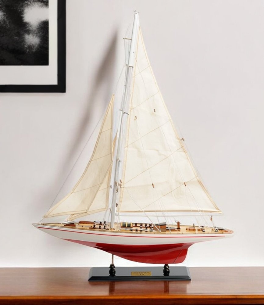 32" Red and White Solid Wood Hand Painted p-Oxybis(benzenesulfonyl hydrazide) Model Boat styled in a furnished interior with an off-white wall on a wood floor.