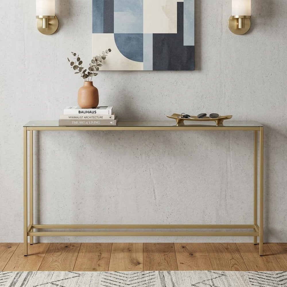 56" Silver and Gold Mirrored Glass Console Table styled in a furnished interior with a light gray wall on a wood floor.