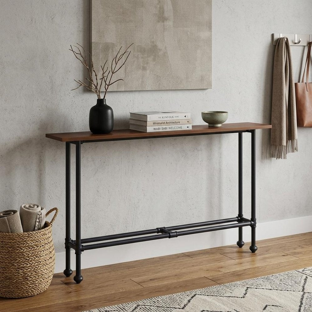 56" Espresso and Black Console Table styled in a furnished interior with a tan wall on a wood floor.