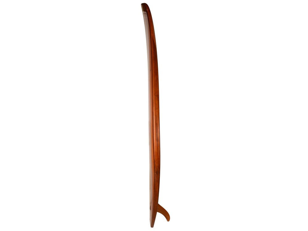 Side view of a 5" brown solid wood surfboard with a fin on a white background.