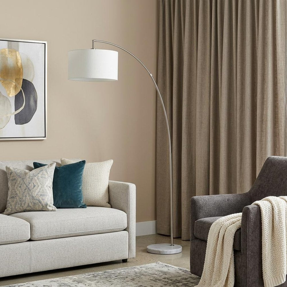 86" White And Silver Arc Floor Lamp With White Drum Shade in a home interior