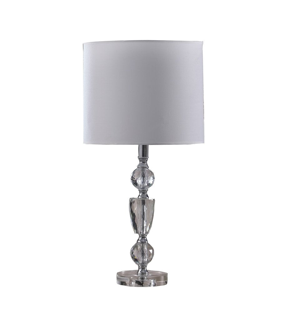 24" Clear And Silver Faux Crystal And Metal Table Lamp With White Drum Shade. Table lamp isolated on a plain white background, showing a silver crystal surface.