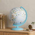 13" Animals of the World Acrylic Globe With LED and Night Light styled in a furnished interior with a cream wall on a dark wood floor in cream.
