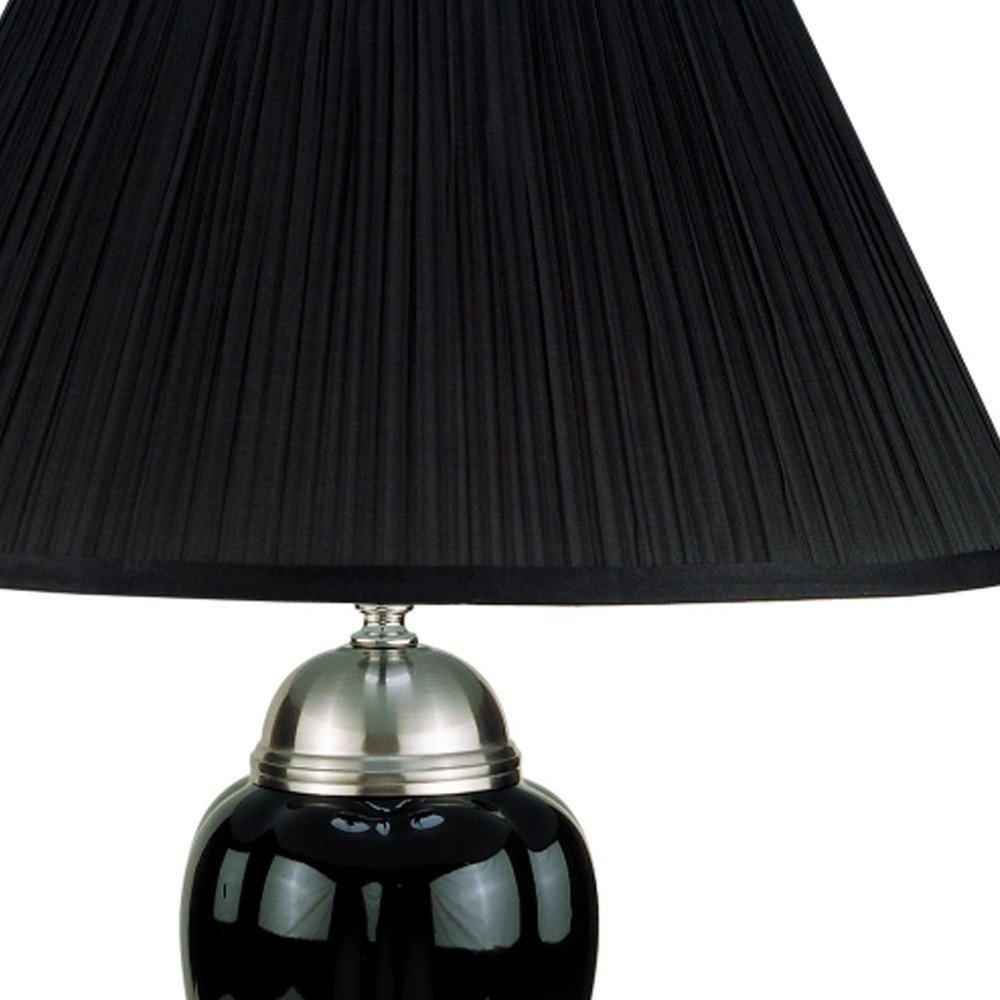 27" Black and Silver Ceramic Urn Table Lamp With Black Empire Shade photographed against a dark studio background in silver.