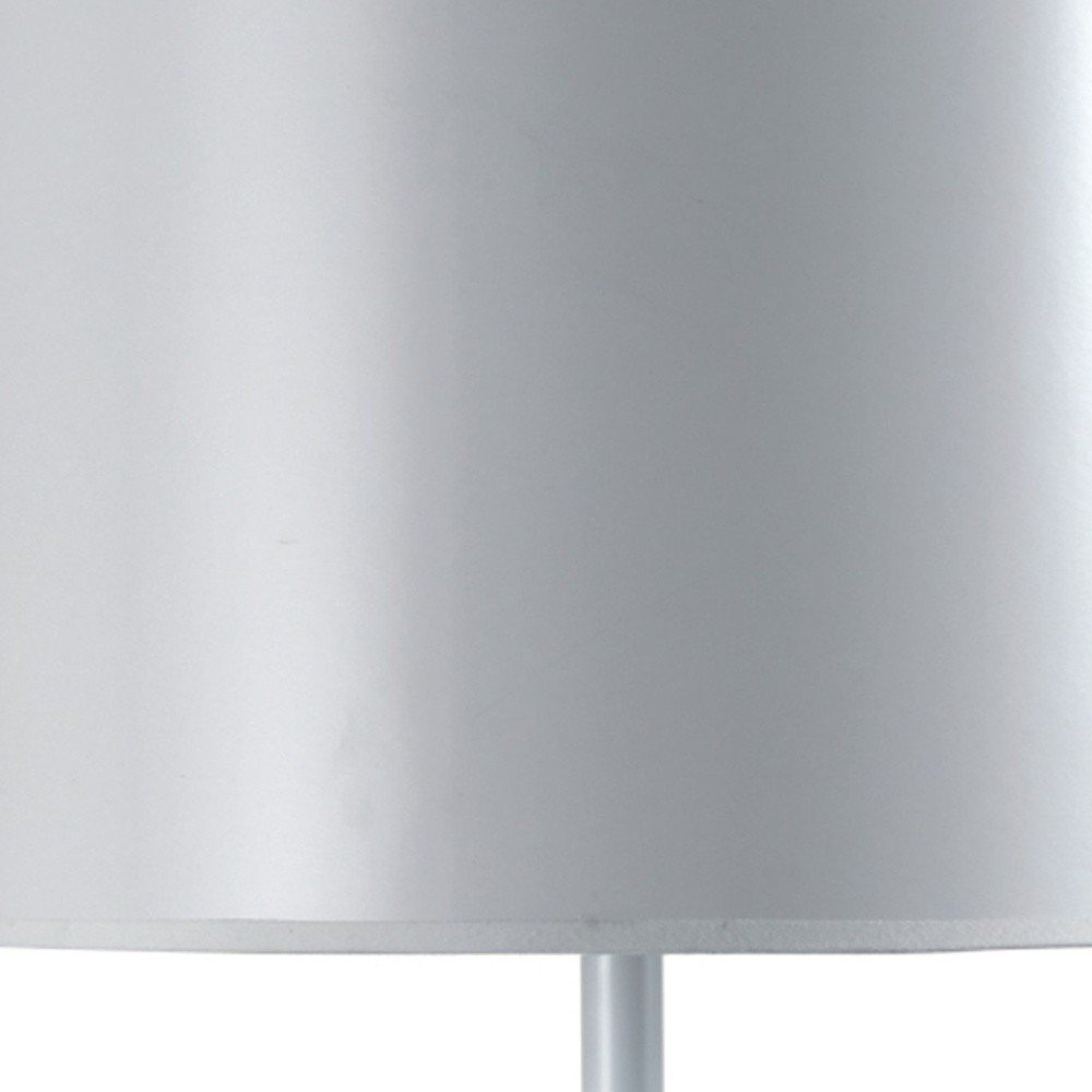 Cropped view of 25" White Metal Table Lamp With White Classic Drum Shade focusing on the white metal surface.