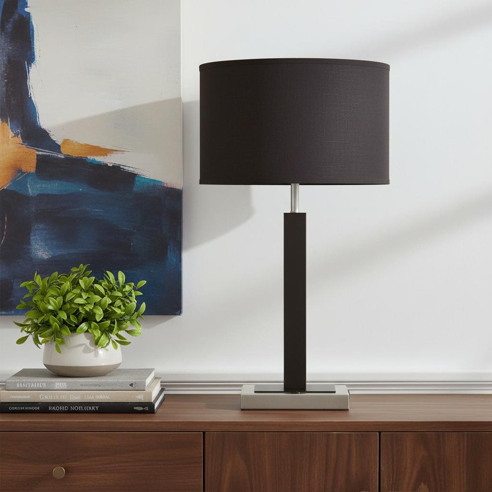 30" Black Polyresin Table Lamp With Brown Classic Drum Shade displayed on a dark wood tabletop in a furnished interior against an off-white wall.