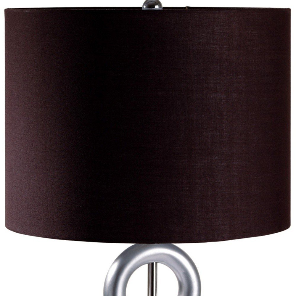 29" Silver Ceramic Geometric Table Lamp With Brown Classic Drum Shade photographed against a dark studio background in silver.