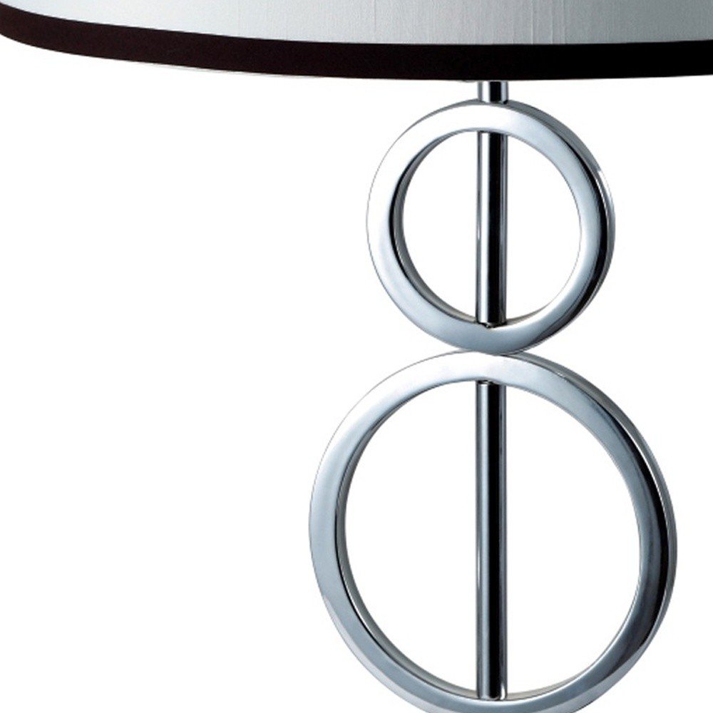 29" Silver Metal Bedside Geo Table Lamp With White and Black Trim Classic Drum Shade. Table lamp isolated on a plain white background, showing a silver metal surface.