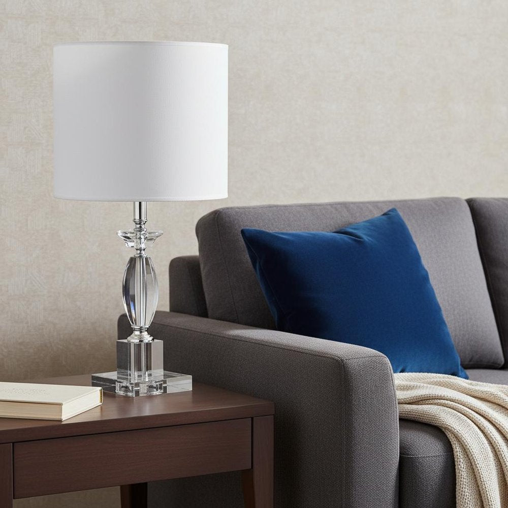 23" Silver Crystal Standard Table Lamp With White Classic Drum Shade Table Lamp displayed on a dark wood tabletop in a furnished interior against an off-white wall.