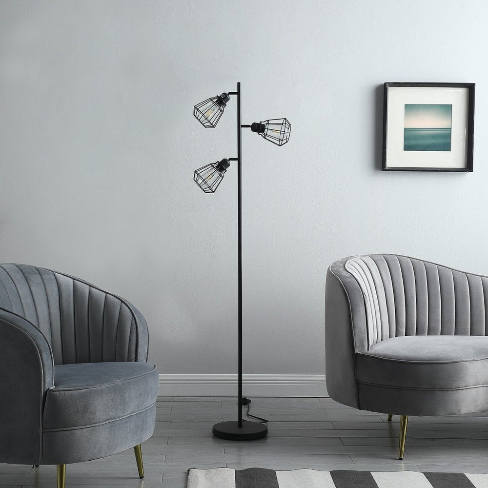66" Black Metal Three Light Tree Floor Lamp With Black Metal Cage Shade standing in a furnished interior on a tiled floor.
