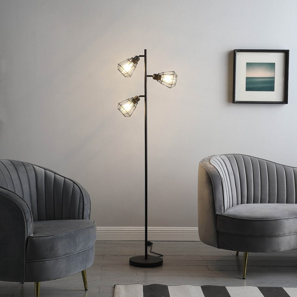 66" Black Metal Three Light Tree Floor Lamp With Black Metal Cage Shade standing in a furnished interior on a charcoal floor.