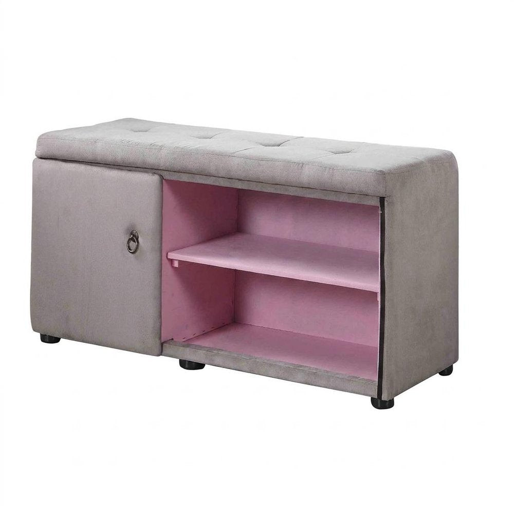 Light gray tufted shoe storage bench with pink interior shelves and a cabinet door with a ring pull, on a white background.