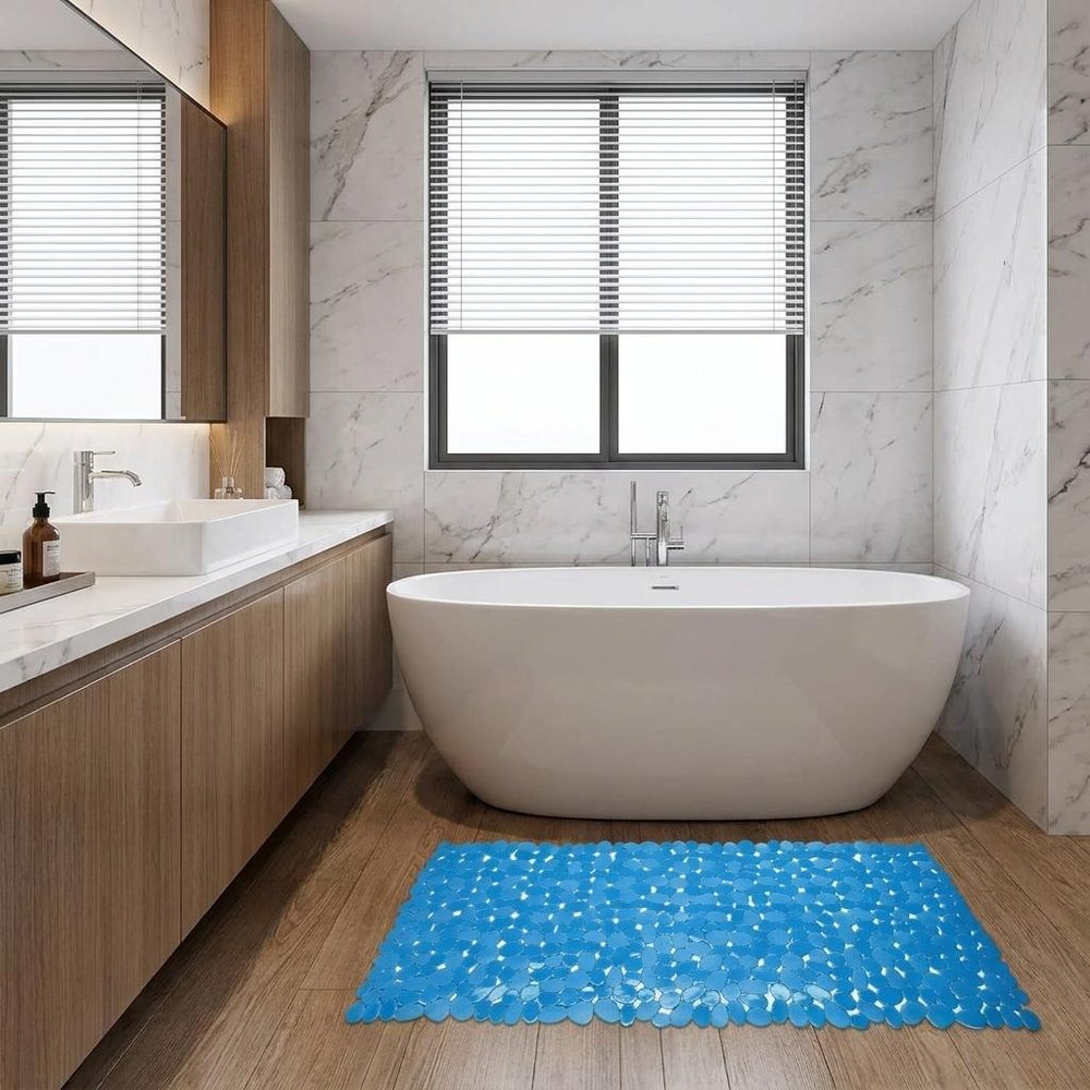 35" Blue Spa Pebbles Non Slip Bathtub Mat styled in a furnished interior with a light gray wall on a blue floor.