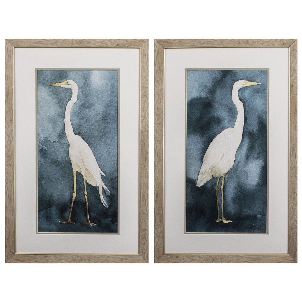 Set of two framed watercolor paintings of white herons against a dark teal blue background.