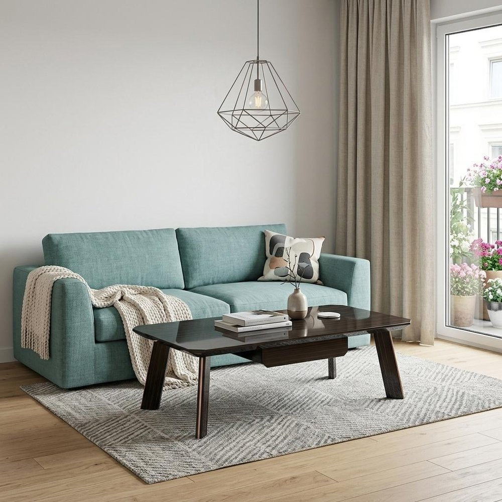55" Ebony and Dark Brown Wood And Stainless Steel Coffee Table With Drawer styled in a furnished interior with a light gray wall on a wood floor.