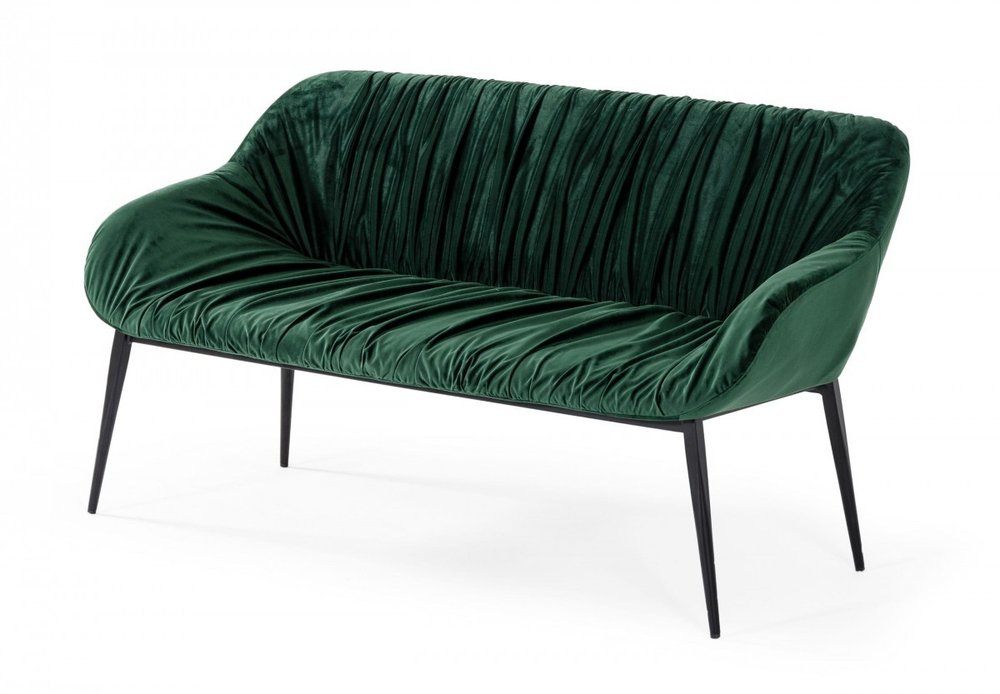 Green velvet upholstered dining bench with black metal legs on a white background.