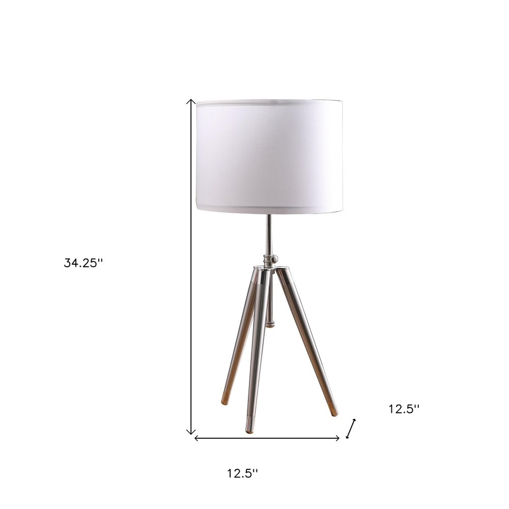 34" Silver Metal Adjustable Tripod Table Lamp With White Round Shade. Table lamp isolated on a plain white background, showing a silver metal surface.