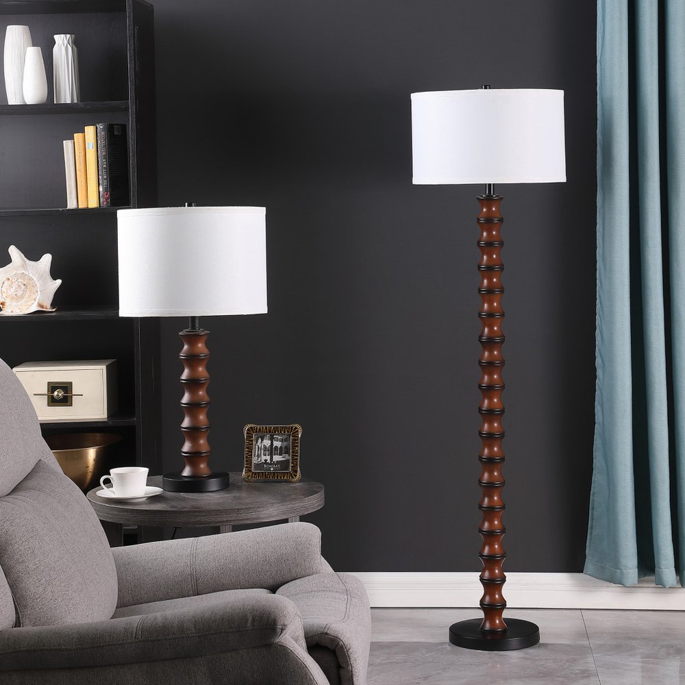 28" Dark Cherry Polyresin Indents Table Lamp With White Shade displayed on a tabletop in a furnished interior against a dark wall.