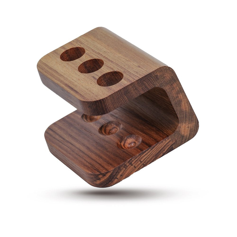 Wooden toothbrush holder with three slots on top and three indentations on the bottom, against a white background.