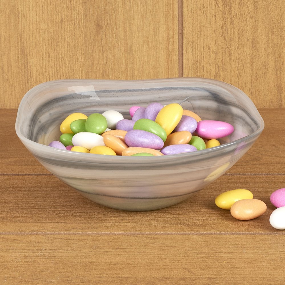 A set of two gray and white alabaster glass square candy bowls filled with pastel-colored candies on a wooden surface.