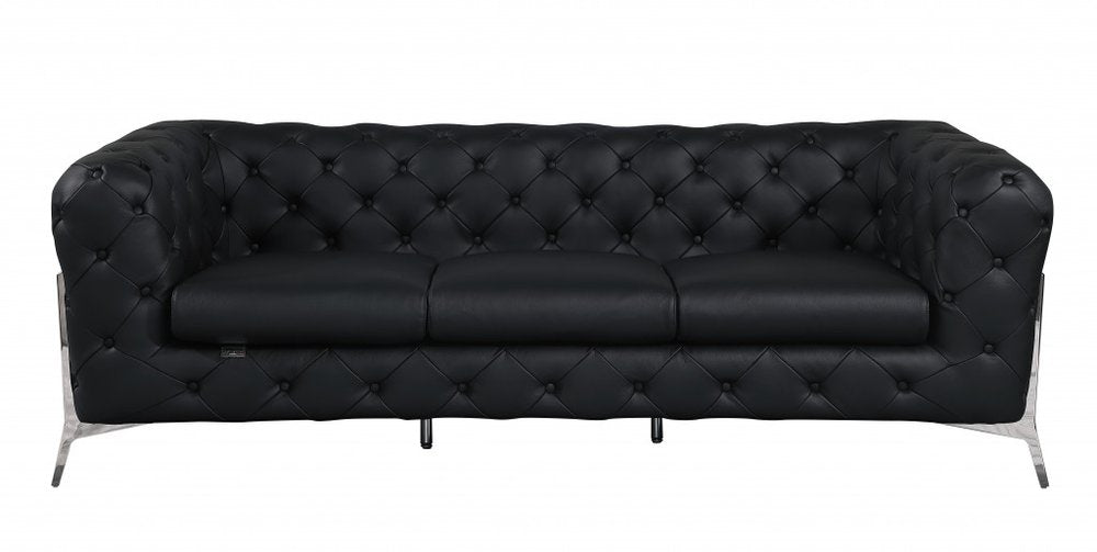 Black Italian leather chesterfield sofa with tufted upholstery and silver legs on a white background.