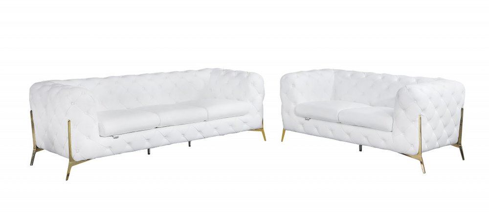 Two white tufted leather sofas with gold legs on a white background.