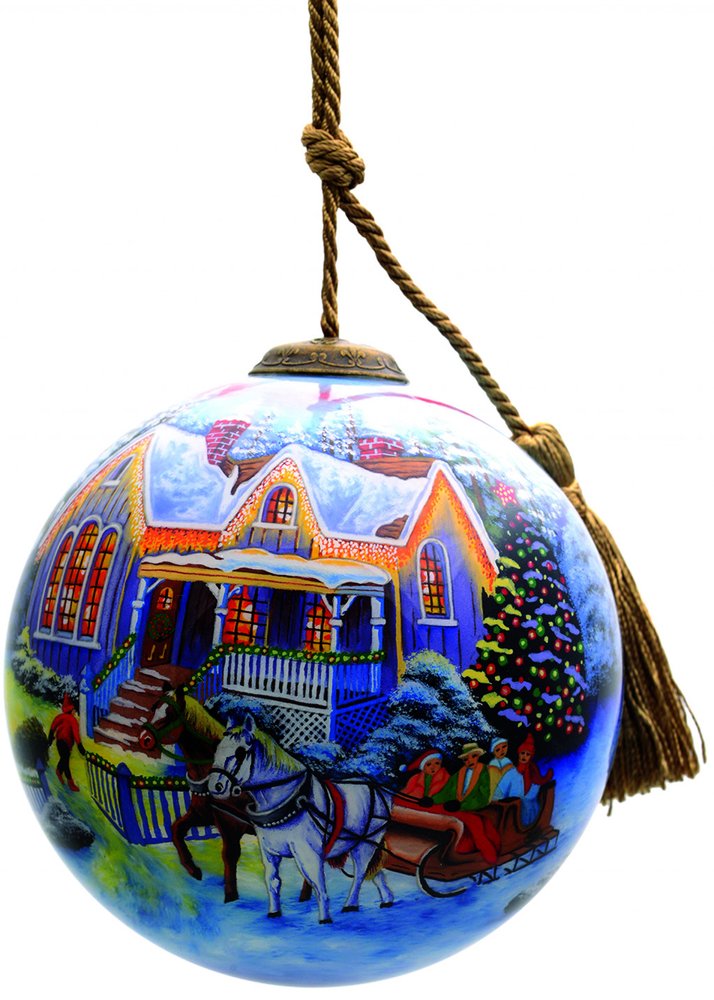 Glass Christmas ornament with a winter scene of a house, horses, and sleigh, featuring blue, white, and yellow colors.