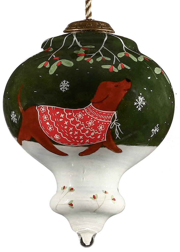 Hand-painted glass Christmas ornament featuring a brown dachshund in a red sweater walking in the snow under mistletoe.
