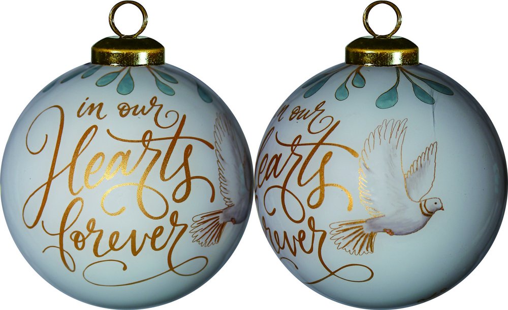 Two white glass ball ornaments with gold lettering that says "in our Hearts forever" and a white dove.