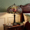 24" Dark Brown Metal Two Light Candlestick Table Lamp With Red Dome Shade displayed on a tabletop in a furnished interior against a sage wall.