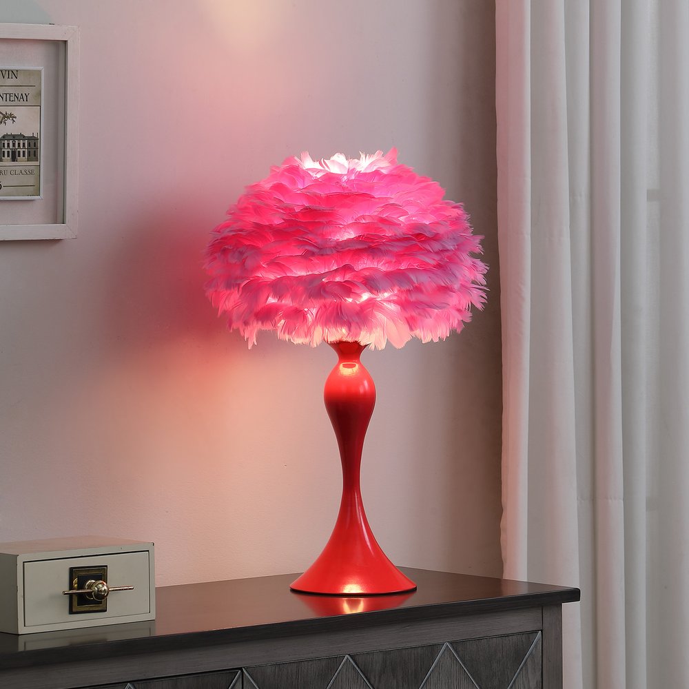 24" Glam Hot Pink Feather and Red Table Lamp displayed on a tabletop in a furnished interior against a blush wall.