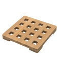 Square wooden trivet with a grid pattern of square cutouts, natural wood finish, on a white background.