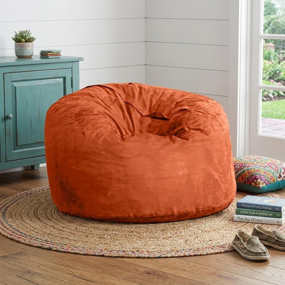 47" Green Microsuede Classic Bean Bag styled in a furnished interior with a light gray wall on a wood floor.