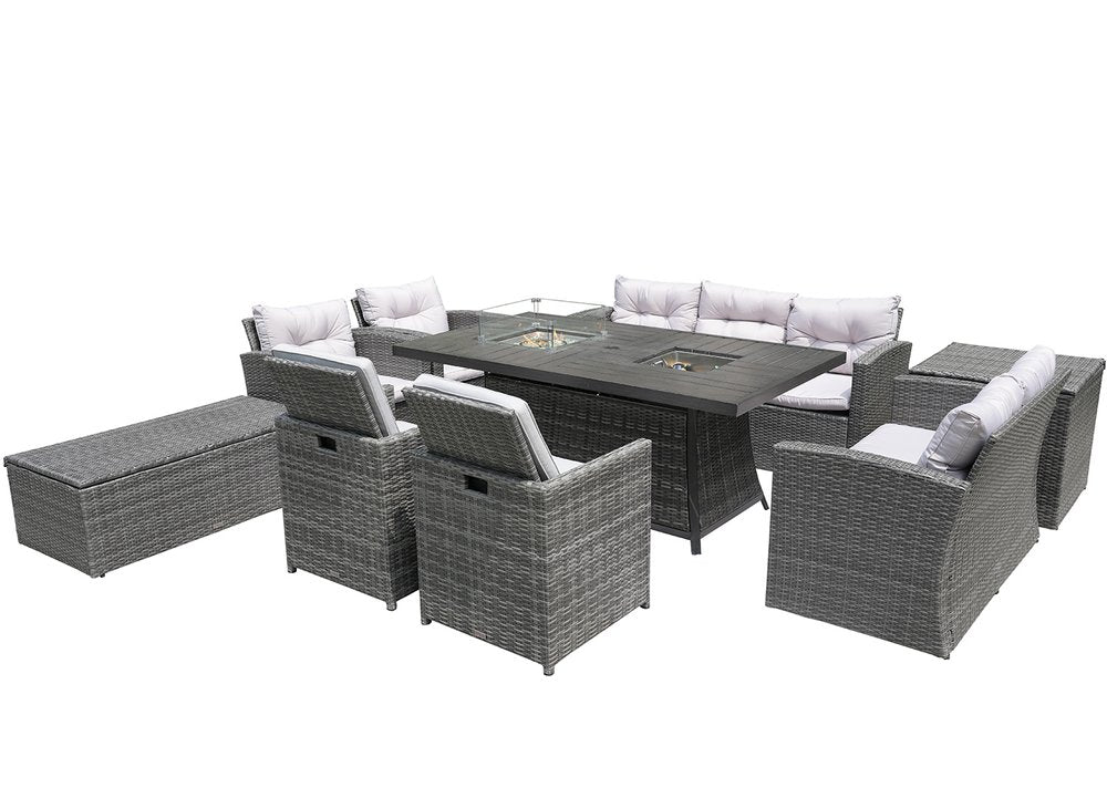 Gray wicker outdoor seating group with fire pit table, sofa, chairs, and storage bench on white background.