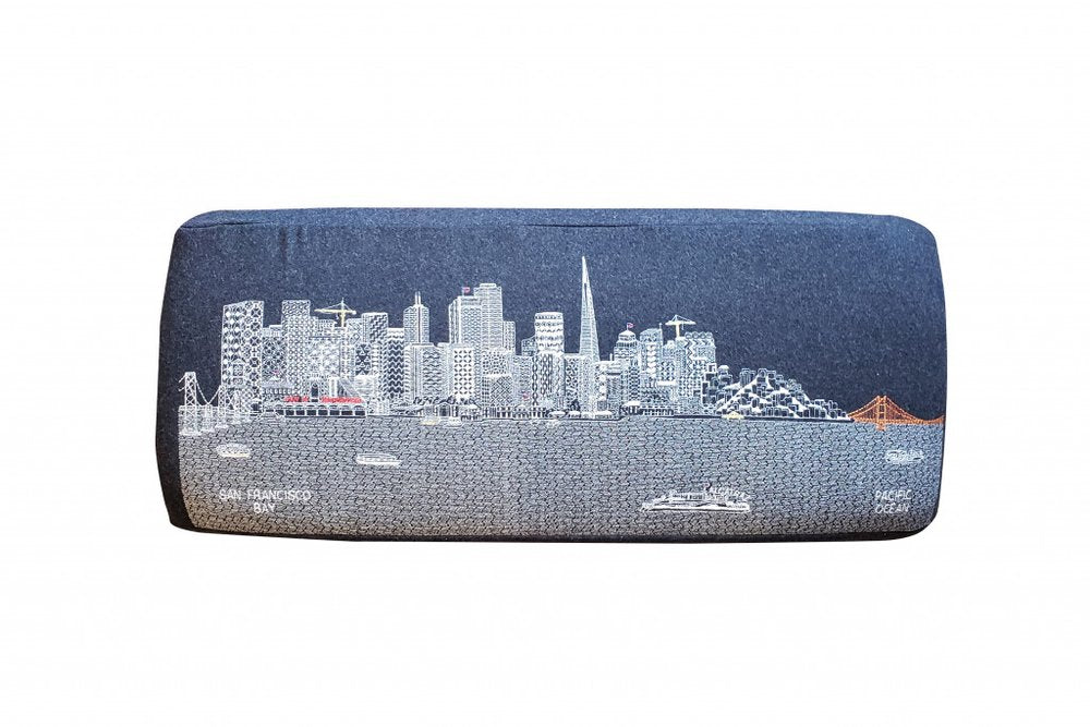 Gray wool ottoman with a white line drawing of the San Francisco skyline and Golden Gate Bridge.