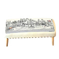Cream wool ottoman with a black and white city skyline print and wooden legs.