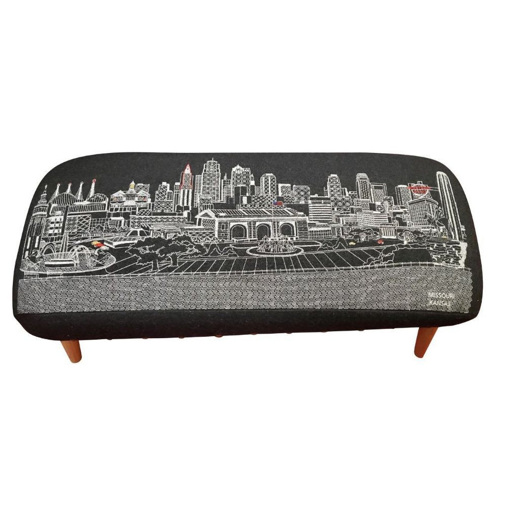 38" Black Wool and Brown Ottoman. Ottoman isolated on a plain white background, showing a black wool surface.