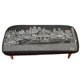 38" Black Wool and Brown Ottoman. Ottoman isolated on a plain white background, showing a black wool surface.