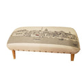 Cream wool ottoman with a black and white Washington D.C. skyline print and four wooden legs.