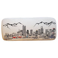 Cream wool ottoman with a black embroidered Denver skyline and mountain scene.