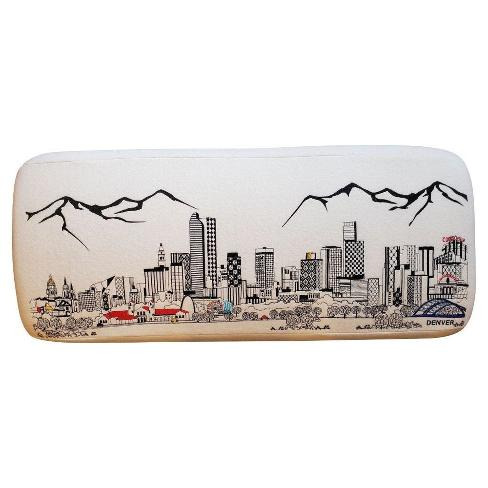 Cream wool ottoman with a black embroidered Denver skyline and mountain scene.