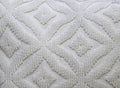 White textured ogee pattern pillow, made of fabric, suitable for indoor or outdoor use.