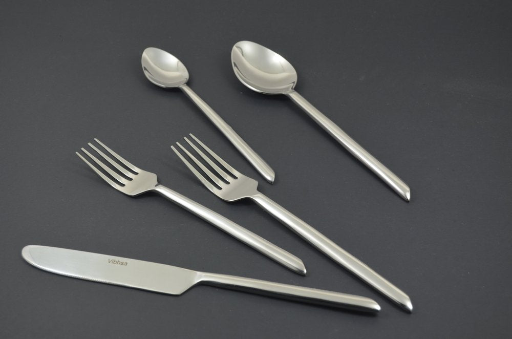 Glossy silver stainless steel flatware set including two spoons, two forks, and one knife on a dark gray background.