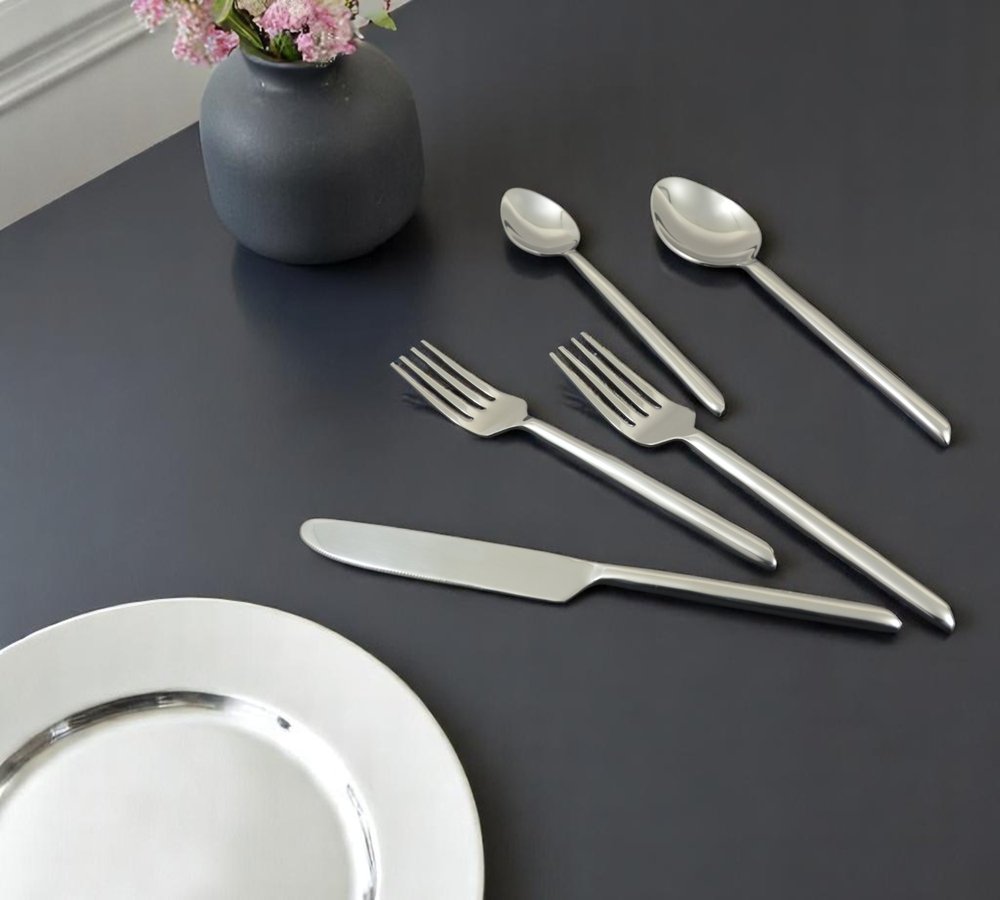 Glossy Silver Stainless Steel Twenty Piece Hand Forged Flatware Set in a home interior
