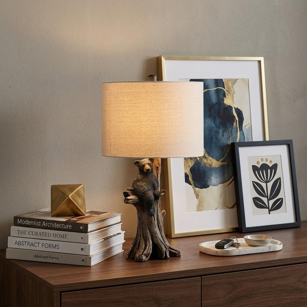 25" Black Bear in a Tree Table Lamp With Beige Shade displayed on a dark wood tabletop in a furnished interior against a tan wall.
